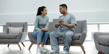 Healthcare provider consulting a patient with a tablet, emphasizing technology in healthcare.