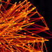 Vibrant orange lines and dots form an abstract network on a dark background, evoking technology and connectivity.