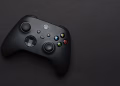 Closeup of a black gaming controller on a dark backdrop, perfect for tech themes.