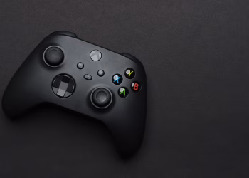 Closeup of a black gaming controller on a dark backdrop, perfect for tech themes.