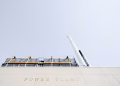 A modern power plant exterior with smokestacks under a clear sky in London, Ontario.