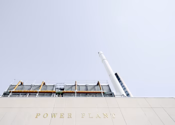 A modern power plant exterior with smokestacks under a clear sky in London, Ontario.