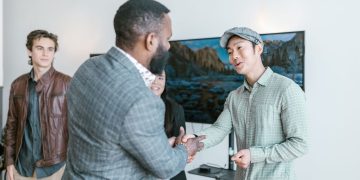 사무실에서 악수하는 다양한 사업가들 - 벤처캐피털 투자 협력