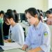 A group of students focused on computer screens in a modern classroom setting.