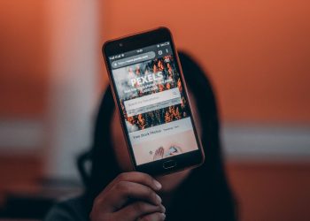 Close-up of a woman browsing Pexels website on a smartphone, indoors.