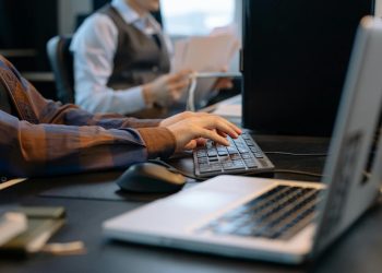 Close-up of office workers engaged in a tech project at a modern workplace.