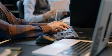 Close-up of office workers engaged in a tech project at a modern workplace.