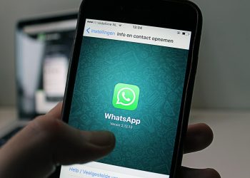 A smartphone displaying the WhatsApp application screen held by a person.