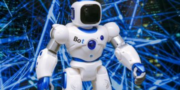 Advanced humanoid robot with glowing blue accents in a digital network setting.