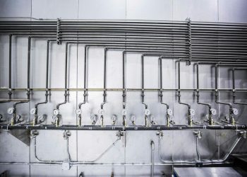 Detailed view of an industrial plumbing system featuring multiple pressure gauges and steel pipes.
