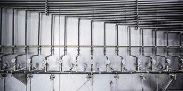 Detailed view of an industrial plumbing system featuring multiple pressure gauges and steel pipes.