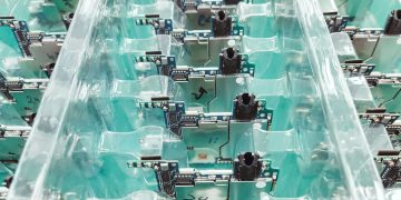 Detailed view of organized electronic circuit boards in a production setting.