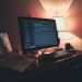Warmly lit home office with dual screens for coding and programming. Perfect modern workspace for tech enthusiasts.