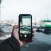 Person captures an urban winter scene on a smartphone, focusing on the street view ahead.