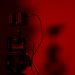 Minimalist close-up of a camera setup in dramatic red lighting, perfect for creative photography projects.