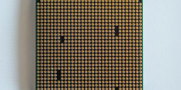 Detailed view of a computer processor, showcasing its pins, against a clean white backdrop.