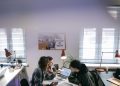A group of people discussing ideas around laptops in a bright, modern office space.
