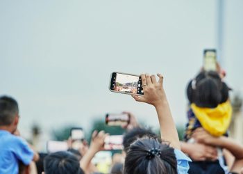 A lively crowd capturing an event on smartphones, showcasing modern digital engagement.