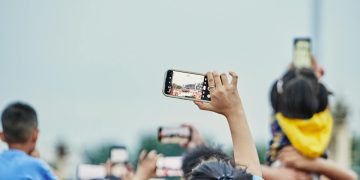 A lively crowd capturing an event on smartphones, showcasing modern digital engagement.