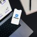 Smartphone displaying Alipay app on open laptop with online shopping site.