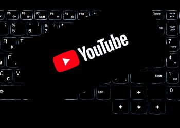 YouTube logo displayed on a backlit keyboard, representing digital media and online content creation.