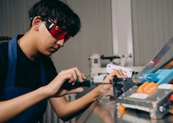 보호안경을 쓰고 정밀 작업을 하는 노동자 - 고용