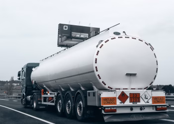 Rear view of a large tanker truck transporting fuel on a highway, emphasizing logistics and transportation.