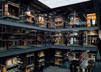 An intriguing view of a modern art museum interior with multiple floors and visitors observing exhibits.