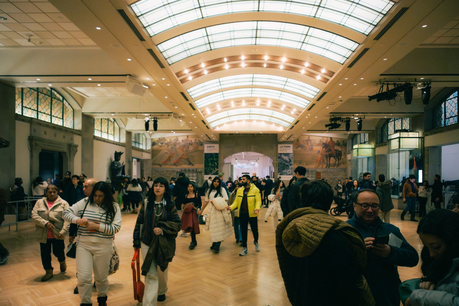 People exploring a vibrant art exhibit inside a Toronto museum hall.