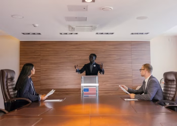 Three professionals deliberating in a modern conference room setting.