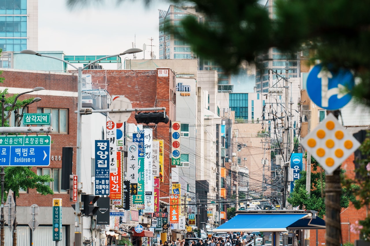 A bustling street in a city with many signs.