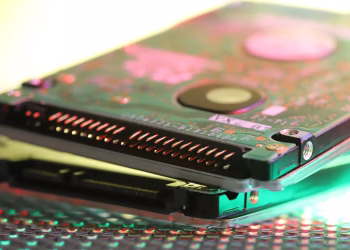 Detailed view of a computer hard disk circuit board with colorful reflections.