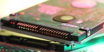 Detailed view of a computer hard disk circuit board with colorful reflections.