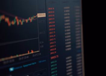 Close-up of a computer screen showing dynamic financial market data and charts, indicating real-time trading updates.