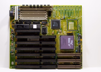 Close-up of a vintage motherboard showcasing Intel microprocessor and slots for hardware integration.