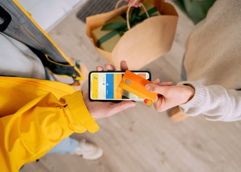 Person making contactless payment with a credit card using smartphone. Online shopping and delivery concept.