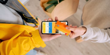 Person making contactless payment with a credit card using smartphone. Online shopping and delivery concept.