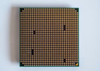 Detailed view of a computer processor, showcasing its pins, against a clean white backdrop.