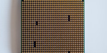 Detailed view of a computer processor, showcasing its pins, against a clean white backdrop.