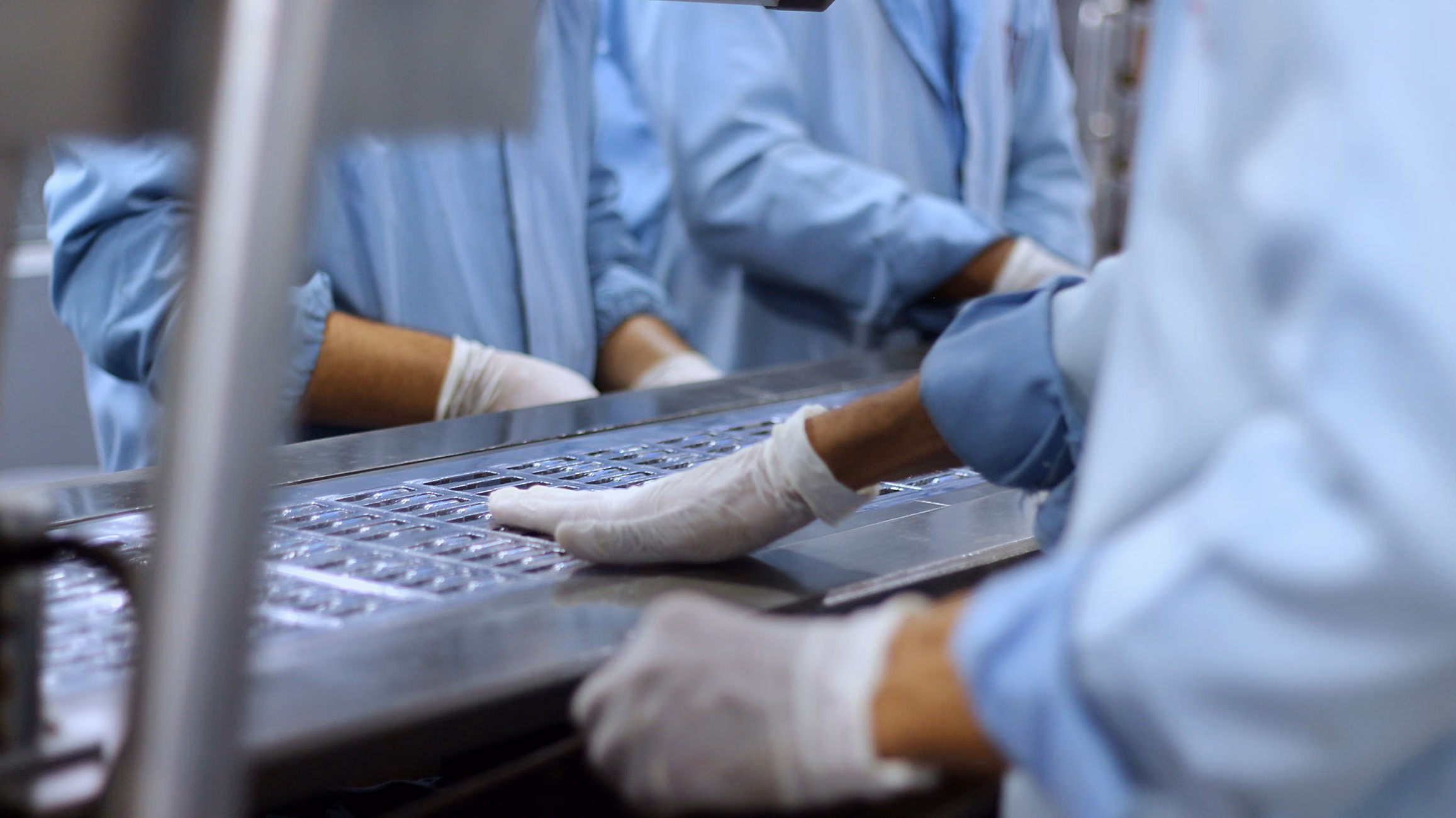 Workers in a pharmaceutical facility packaging tablets in Islamabad.