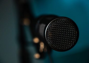 Detailed image of a black microphone with selective focus in a studio environment.