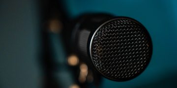 Detailed image of a black microphone with selective focus in a studio environment.