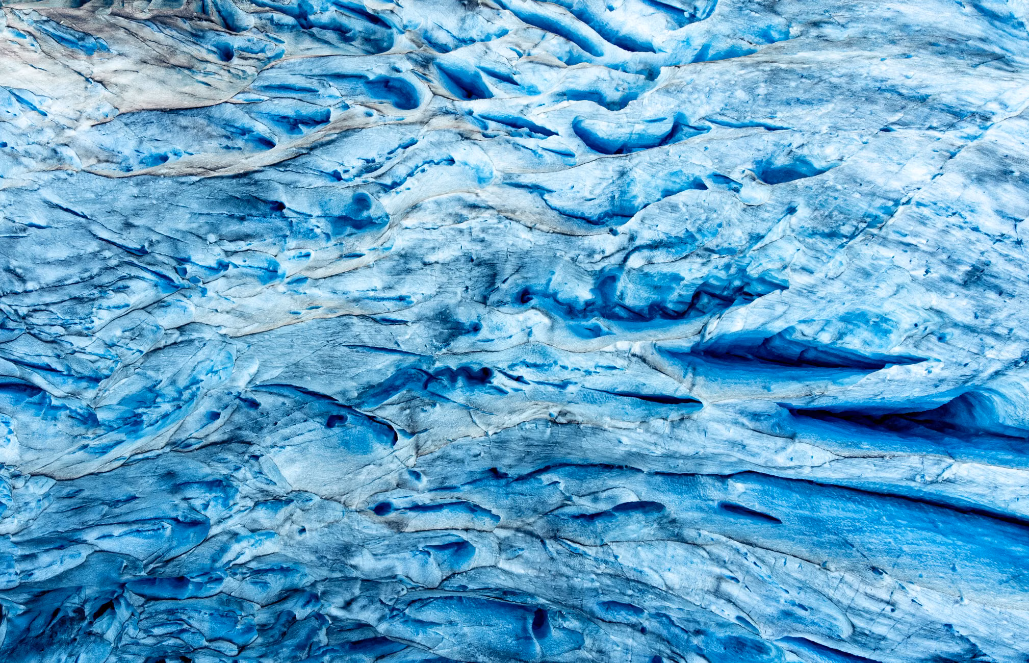 A detailed close-up of vivid blue glacier ice texture showcasing natural patterns.