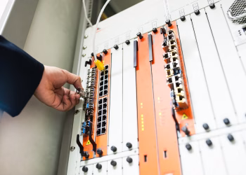Close-up of a hand adjusting network equipment in a data center.