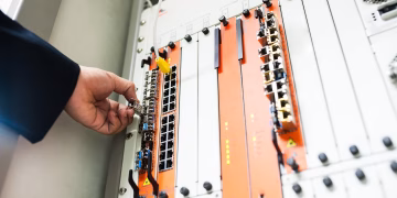 Close-up of a hand adjusting network equipment in a data center.