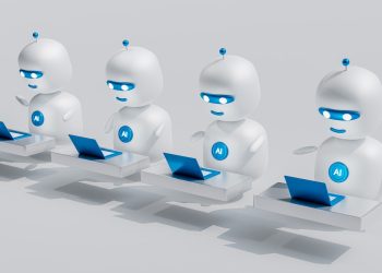 a group of white robots sitting on top of laptops