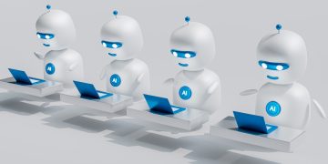 a group of white robots sitting on top of laptops