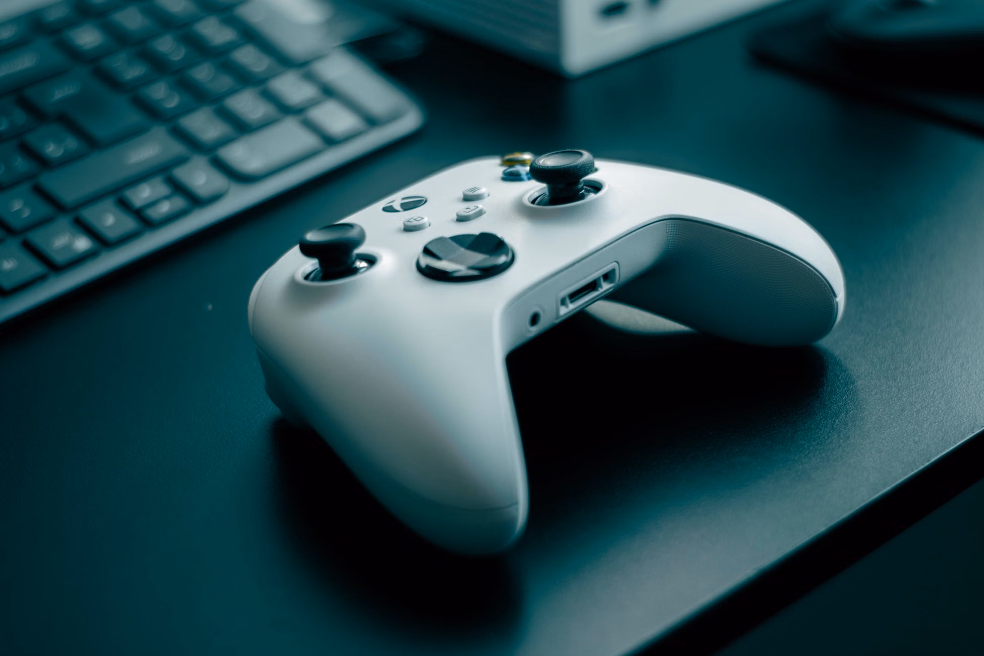 Close-up of a white game controller on a sleek desk, highlighting technology and gaming.
