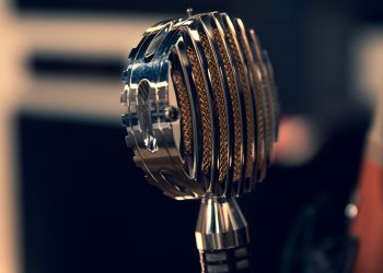 Close-up of a vintage condenser microphone in a recording studio with a focus on intricate details.