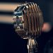 Close-up of a vintage condenser microphone in a recording studio with a focus on intricate details.